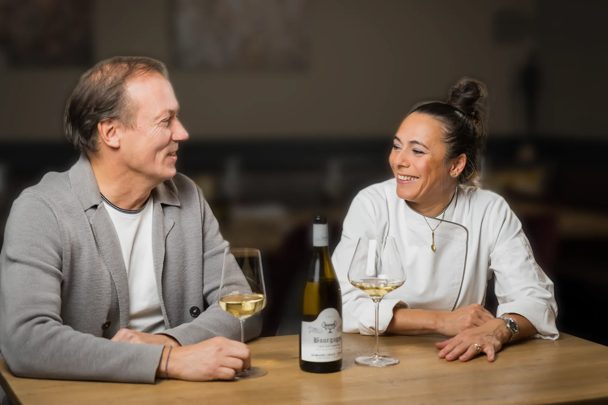 Patrick Fischbacher und Claudia De Luca am Tisch mit einem Glas Weißwein