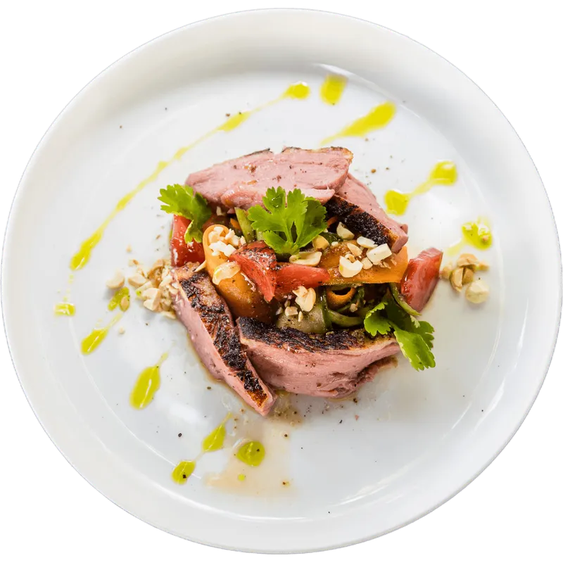 Roastbeef mit Tomate auf weißem Teller, von oben